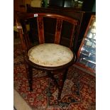 An Edwardian Arts & Crafts Mahogany corner armchair having turned legs united by a turned detail