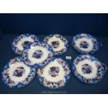 Five flow blue china plates decorated with orange and pink flowers with blue border plus two one