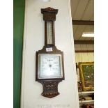 An Oak carved wall mounted barometer with stylish square central glass face and temperature gauge,