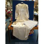 A hand made silk wedding dress with long puffed ball sleeves and beaded detail, train,