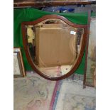 An Edwardian shield shaped beveled Mirror with inlaid strip around the edge.