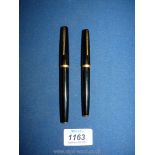 Two Waterman black fountain pens.