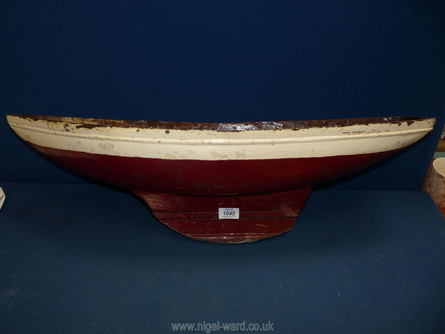A hand carved red and white model boat, 30" long x 8" wide.