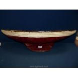 A hand carved red and white model boat, 30" long x 8" wide.