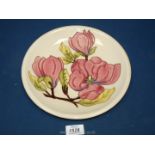 A Moorcroft cream ground Magnolia plate, 10 1/4'' diameter,