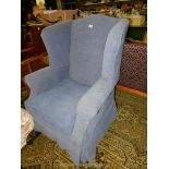 A contemporary winged Fireside Armchair of classical shape and fitted with blue loose covers.