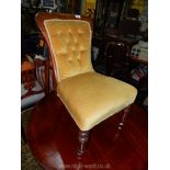 A Mahogany framed gold coloured Dralon upholstered buttoned back Nursing Chair on turned front legs.