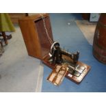 A Frister & Rossmann Hand sewing machine in wooden case with key and booklet.
