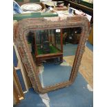 A maroon/brown gesso finished framed rhomboid-shaped wall mirror 35" x 28 3/4", some distress.