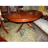 A contemporary circular Mahogany coffee table having cross-banding to the top and standing on a