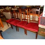 A set of four early 20th century dark-wood framed dining chairs having deep crimson Velvet type
