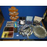 A quantity of mixed cutlery including a rack of souvenir spoons, boxed sets of cake forks,
