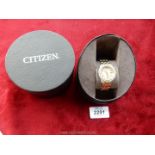 A Citizen Eco-Drive ladies watch with elegant stones around clock face and two tone chain in box.