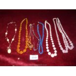 A small quantity of glass bead necklaces and a coral style necklace