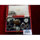 A silver locket, seven silver pendants and a silver and black silhouette brooch in red box.