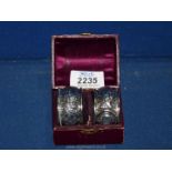 A boxed silver pair of napkin rings, hallmarked Chester 1899,