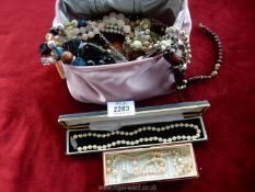 A pink bag of mixed necklaces, two boxed pearl necklaces etc.