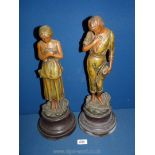 A pair of Spelter figures of a man and woman bowing their heads,
