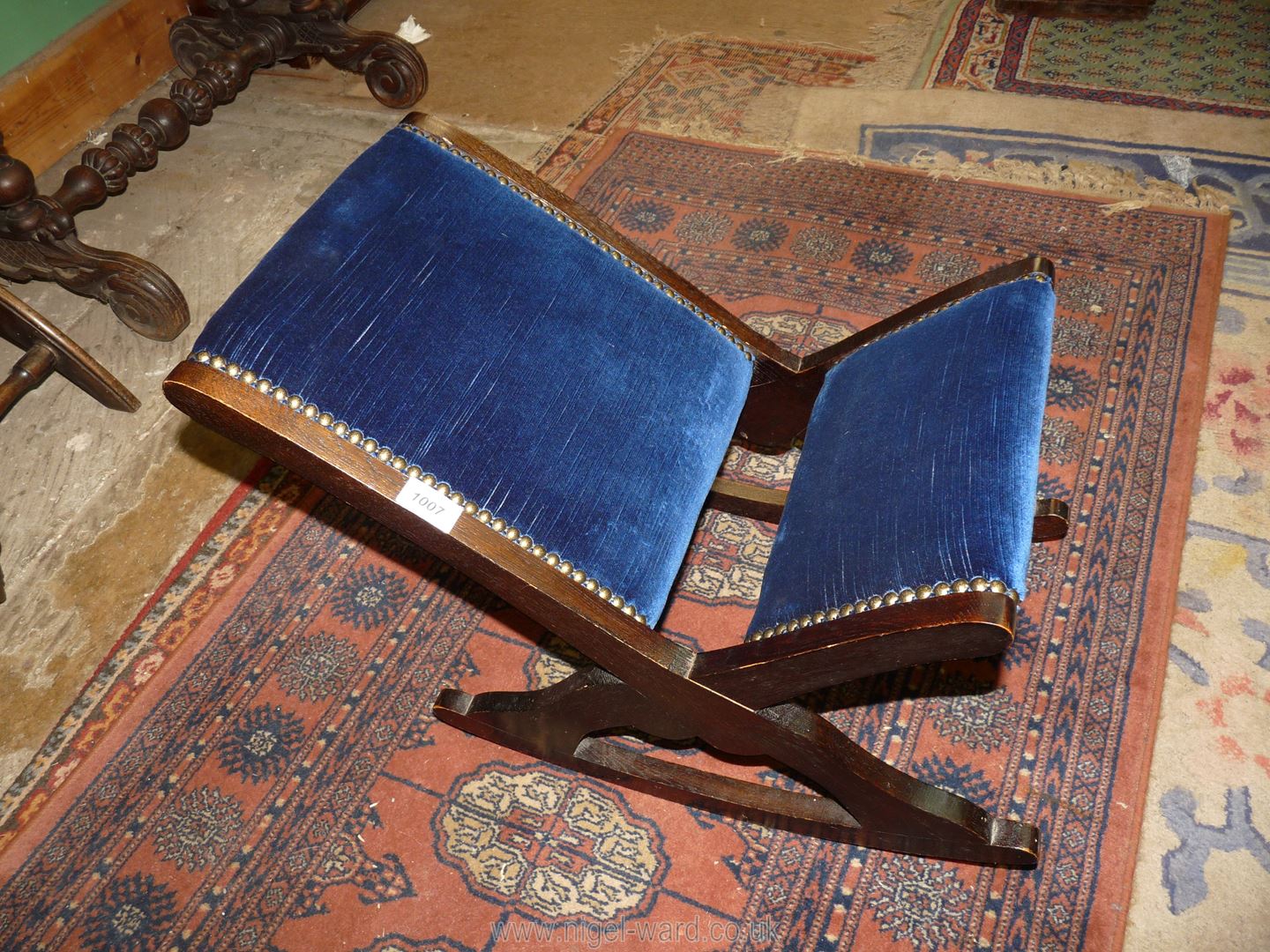 A Gout Stool with blue velvet and stud upholstery.