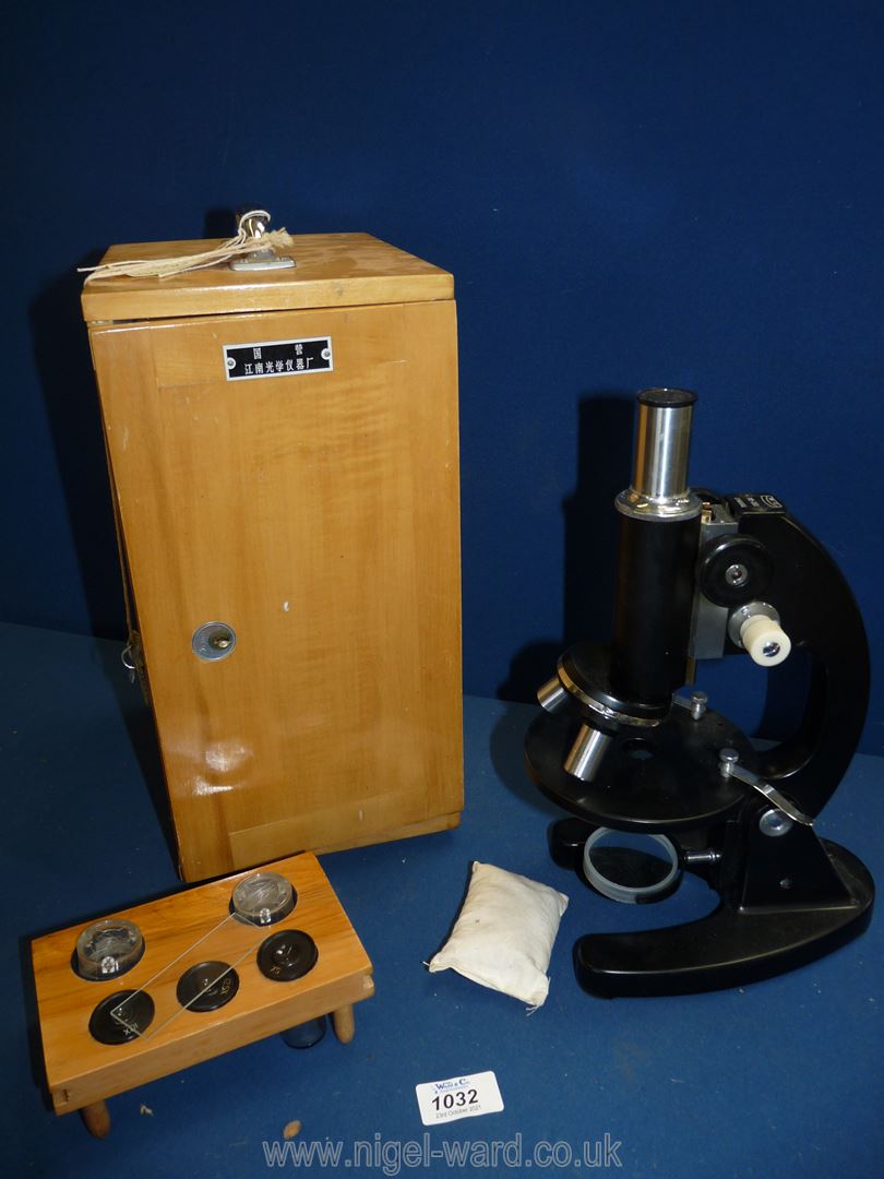 A cased Microscope with various lenses and key.