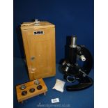 A cased Microscope with various lenses and key.