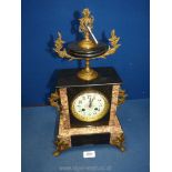 A polished black stone and marble Mantle Clock having an urn pediment and ormolu mounts,