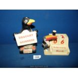 A Carltonware Guinness lamp base in the form of a penguin and a heritage Toucan perpetual calendar.
