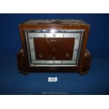 A wooden square mantle clock with Arabic numerals, no key, with pendulum.