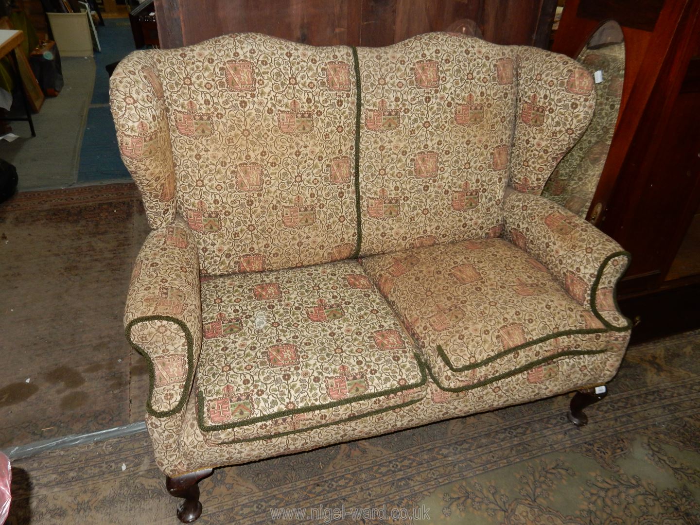 A pre 1950 Georgian design two seater Sofa having winged back and standing on brief Mahogany