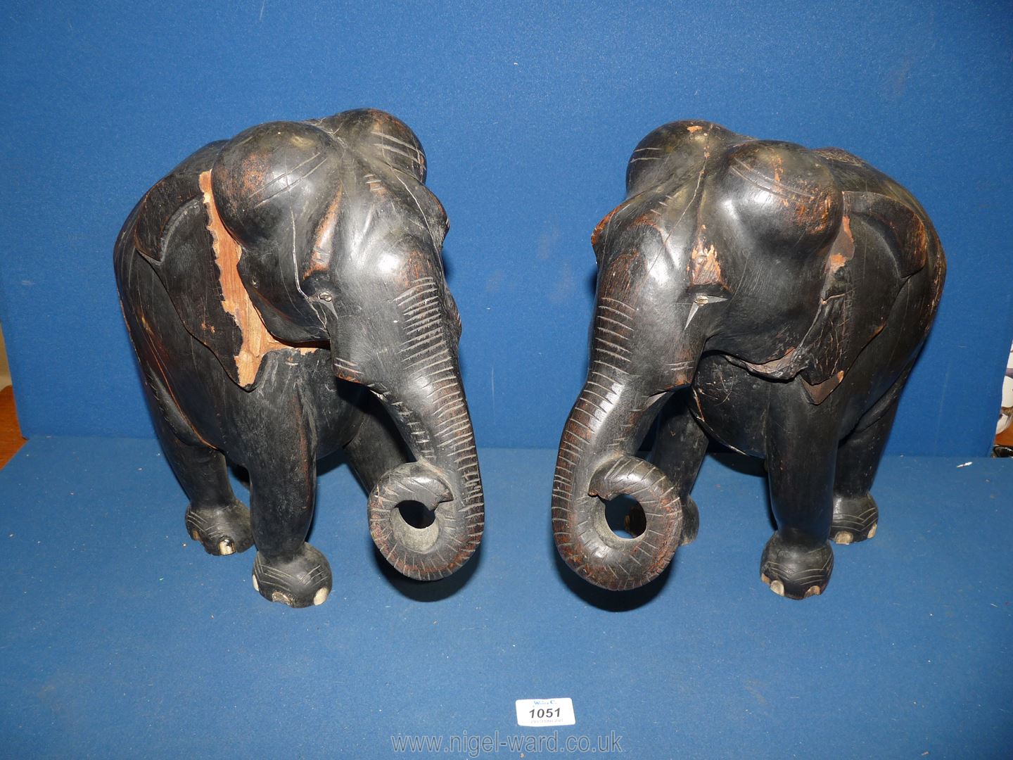 A pair of large and heavy ebonised Elephants, both a/f with large wood splits/losses,