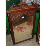 A bevelled edge wooden rectangular mirror with some relief stylised carving to the top with shaped