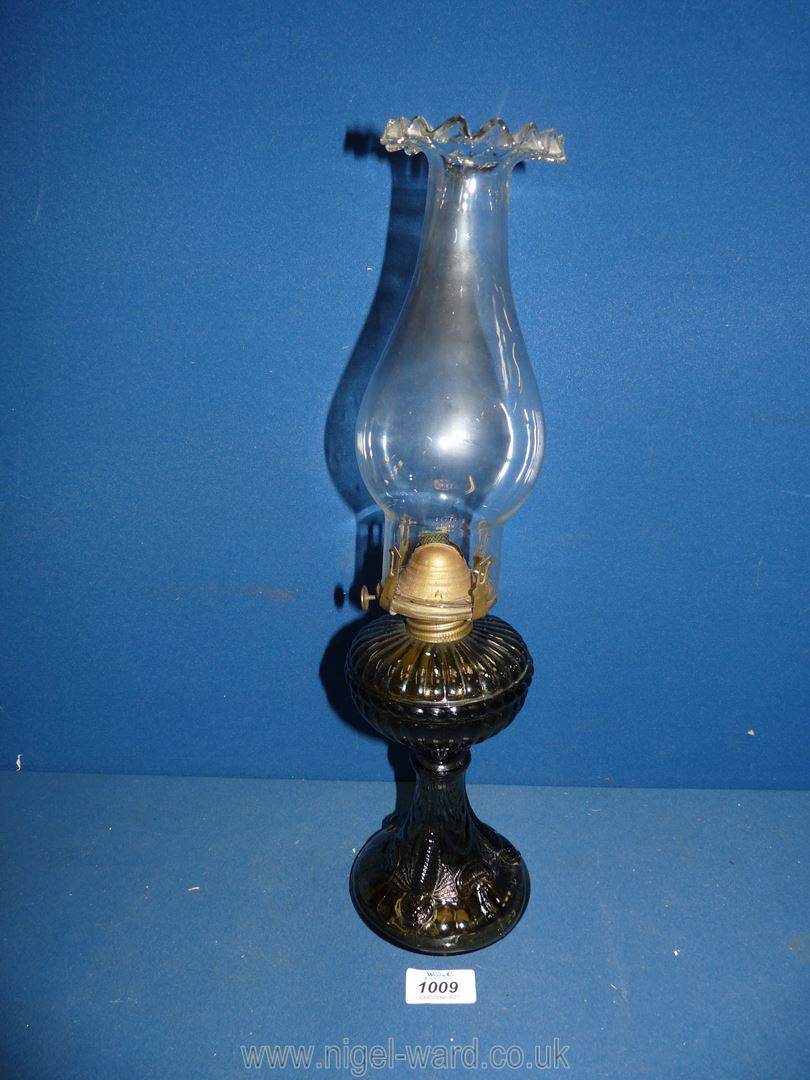 An oil Lamp with smoky brown glass base incorporating the reservoir, with fluted rim chimney,