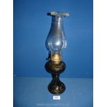 An oil Lamp with smoky brown glass base incorporating the reservoir, with fluted rim chimney,