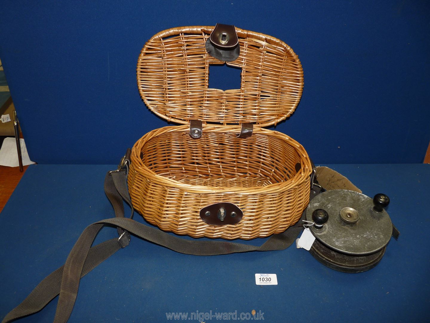 A vintage wicker Creel and a large deep sea fishing Reel with Bakelite handles, 6'' diameter.