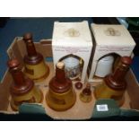 Six empty Wade Bell's Whisky bell decanters including Royal Weddings, and a miniature whisky bottle,