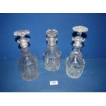 Three old glass decanters with stoppers.