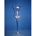 A tall clear glass table centrepiece or candle stand,