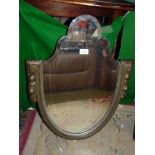 A wooden shield shaped bevelled edge mirror.