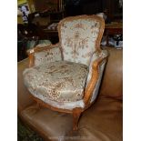 A show framed boudoir/elbow Chair standing on swept framed legs and upholstered in beige ground