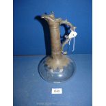 A Claret jug with white metal neck and handle and clear plain glass onion shaped base.