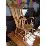 An elegant and other woods Windsor style rocking Armchair having shaped central back splat flanked