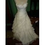 A white strapless wedding dress by Essence having sequins and ruffled organza, size 10.