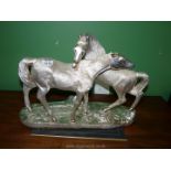 A heavy cast contemporary model of two horses with silver coloured coating,