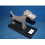 A bronze figure of a Terrier on a dark marble plinth,