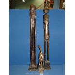 Two large and one smaller wooden carved African figures.