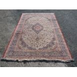 A large Rug in red, blue and cream with central lozenge, 78'' x 120''.