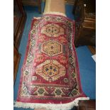 A pink ground Rug having medallions to the centre, fringed. 58 1/4" long x 35 3/4" wide.