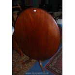 An oval Mahogany snap-top Table having a turned central pillar with four splay feet,