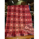 A Welsh blanket in red, white, grey and black, Derw Mill, has a small pulled part of blanket,