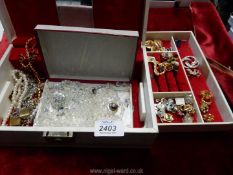 A white jewellery box and costume jewellery including earrings, brooches, necklaces etc.